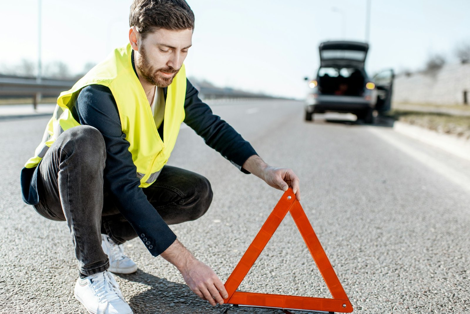 Man putting emergency sign on the road