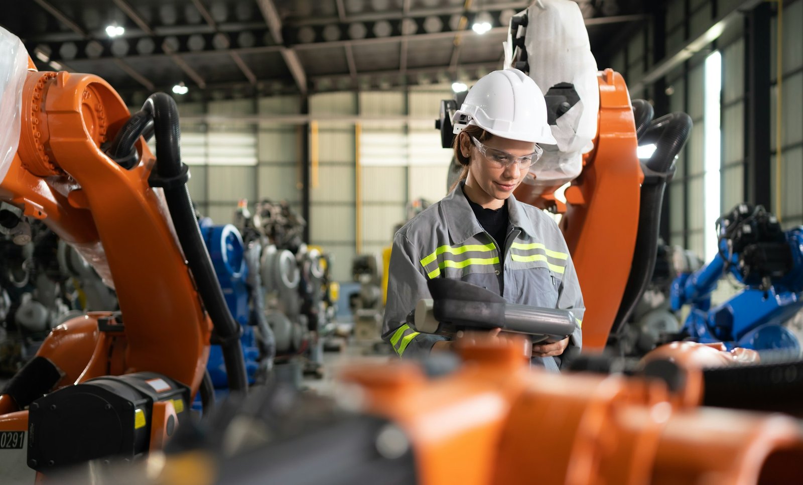 After installing a program on the robotic arm, a female engineer with a robotic arm